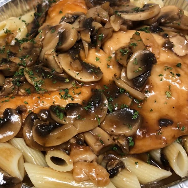 Chicken and mushrooms in a rich brown sauce, garnished with parsley, served over penne pasta.